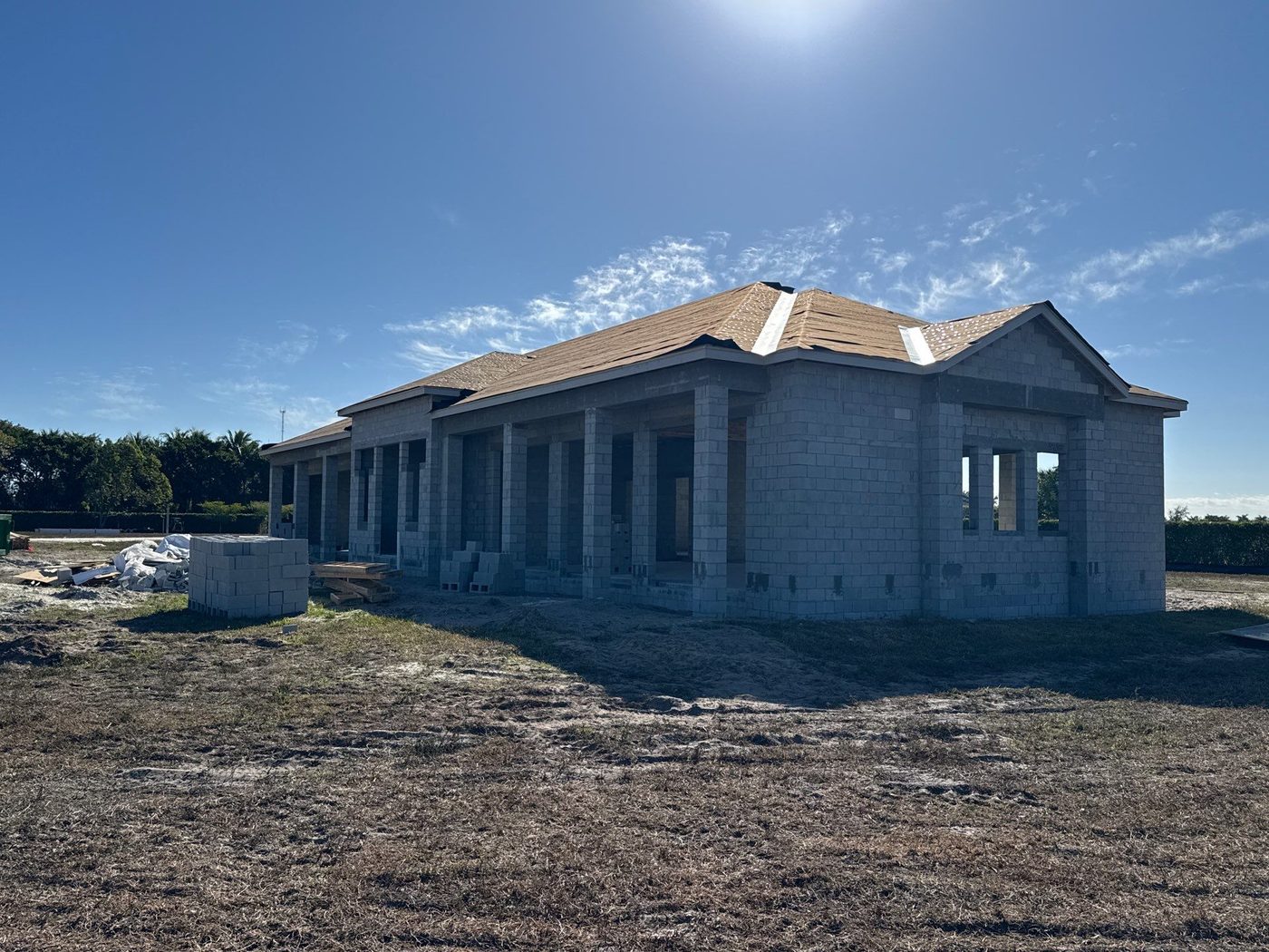 Concrete structural shell with columns rising against a clear sky
