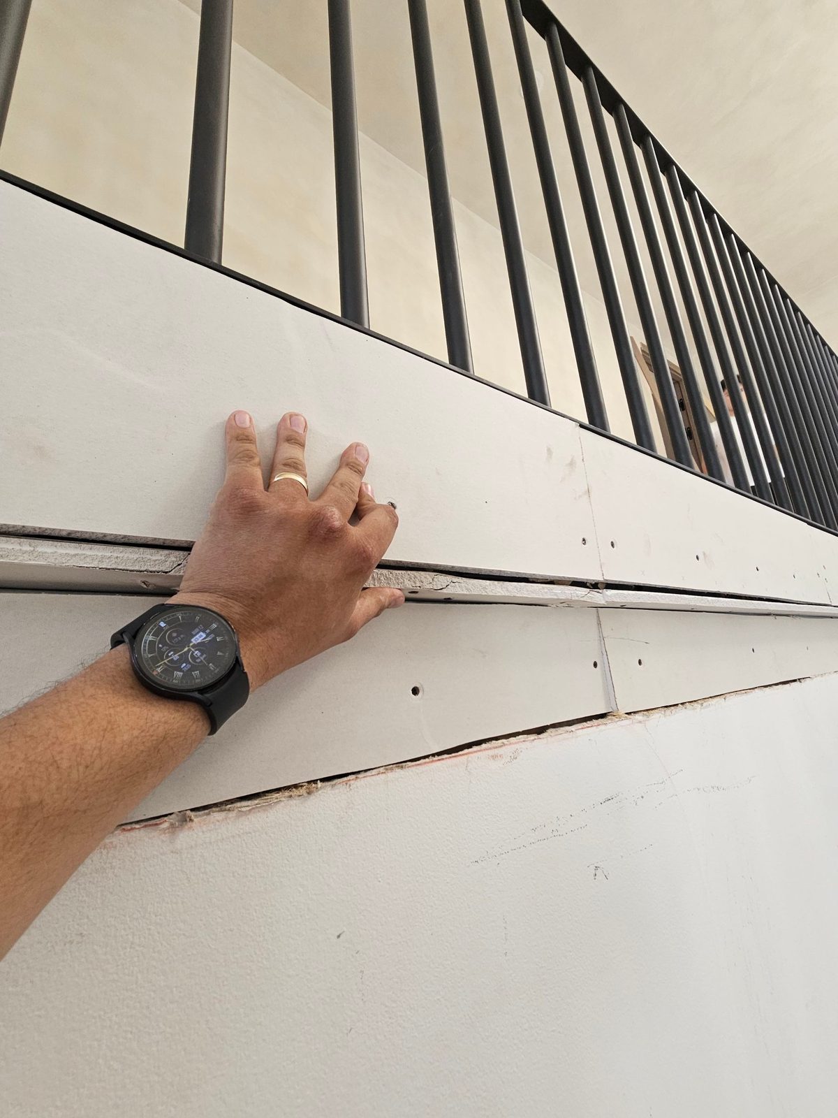 Close detail of a drywall sheet being fitted to a ceiling