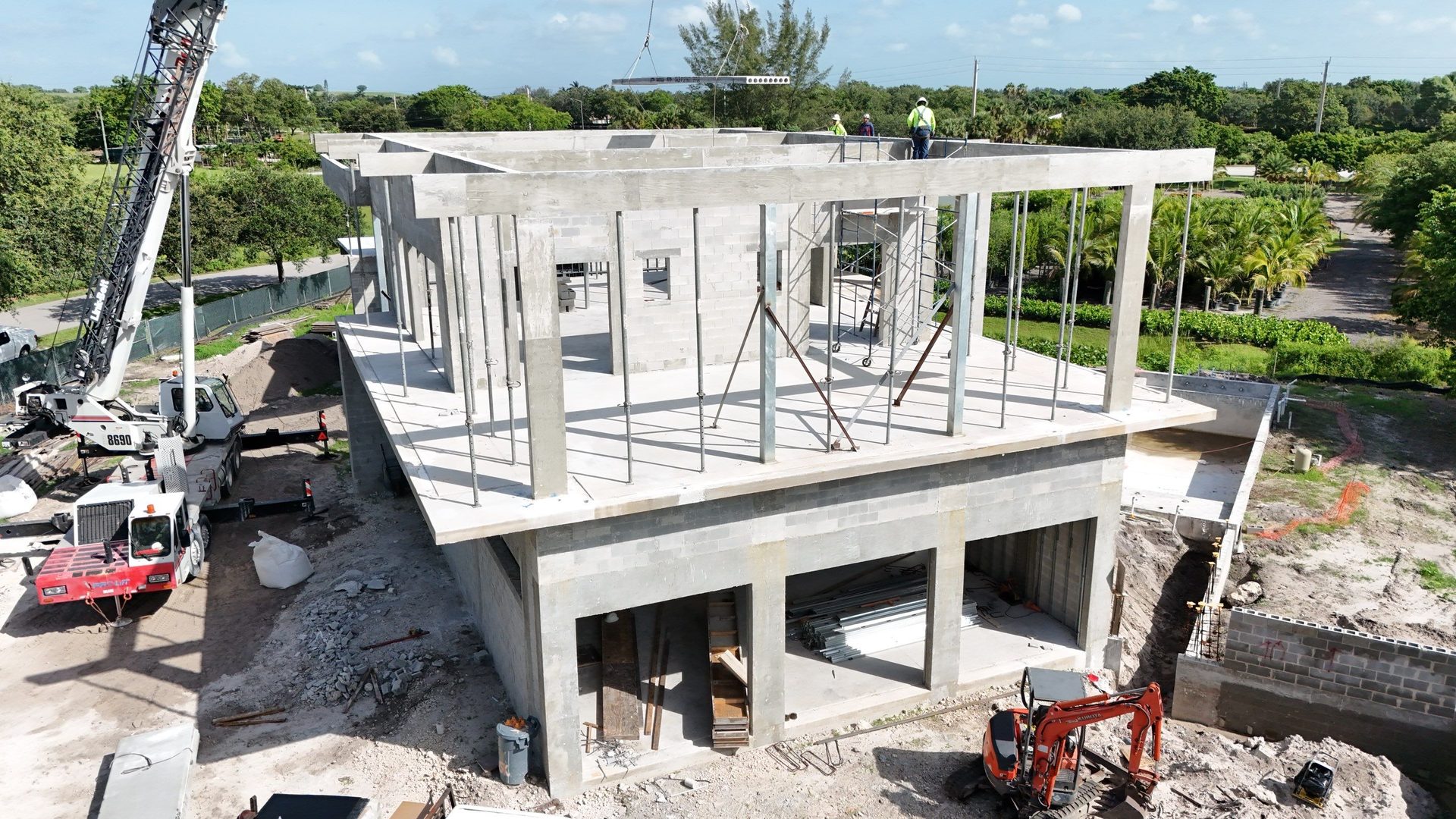 Two-story concrete structural shell with tower crane on site